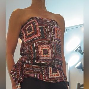 Juggler dotted strapless blouse with elastic back and cinch tie at waist.